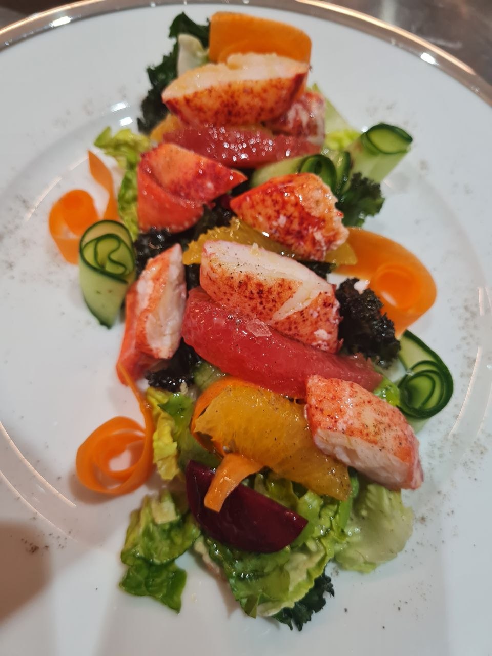 Lobster salad with pink grapefruit, orange, beetroot, kale and ribbons of carrot and cucumber.