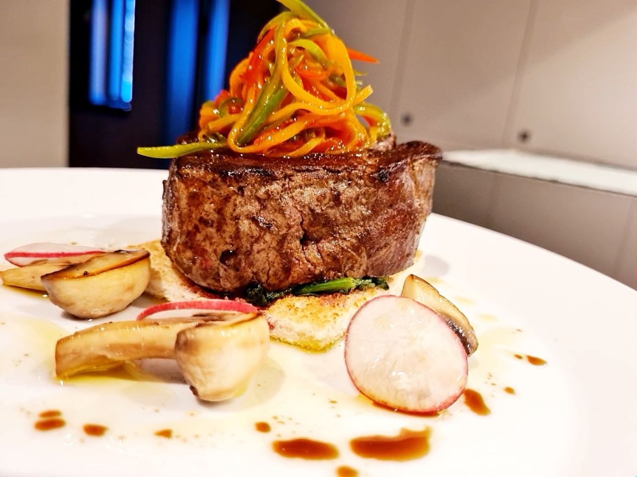 Beef fillet topped with vegetable julienne, with roasted mushrooms, radish, spinach and jus.