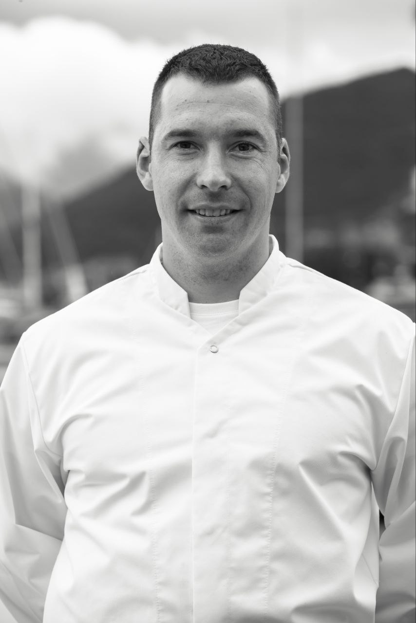 Black-and-white portrait of Goran Veljkovic in a white chef's jacket.